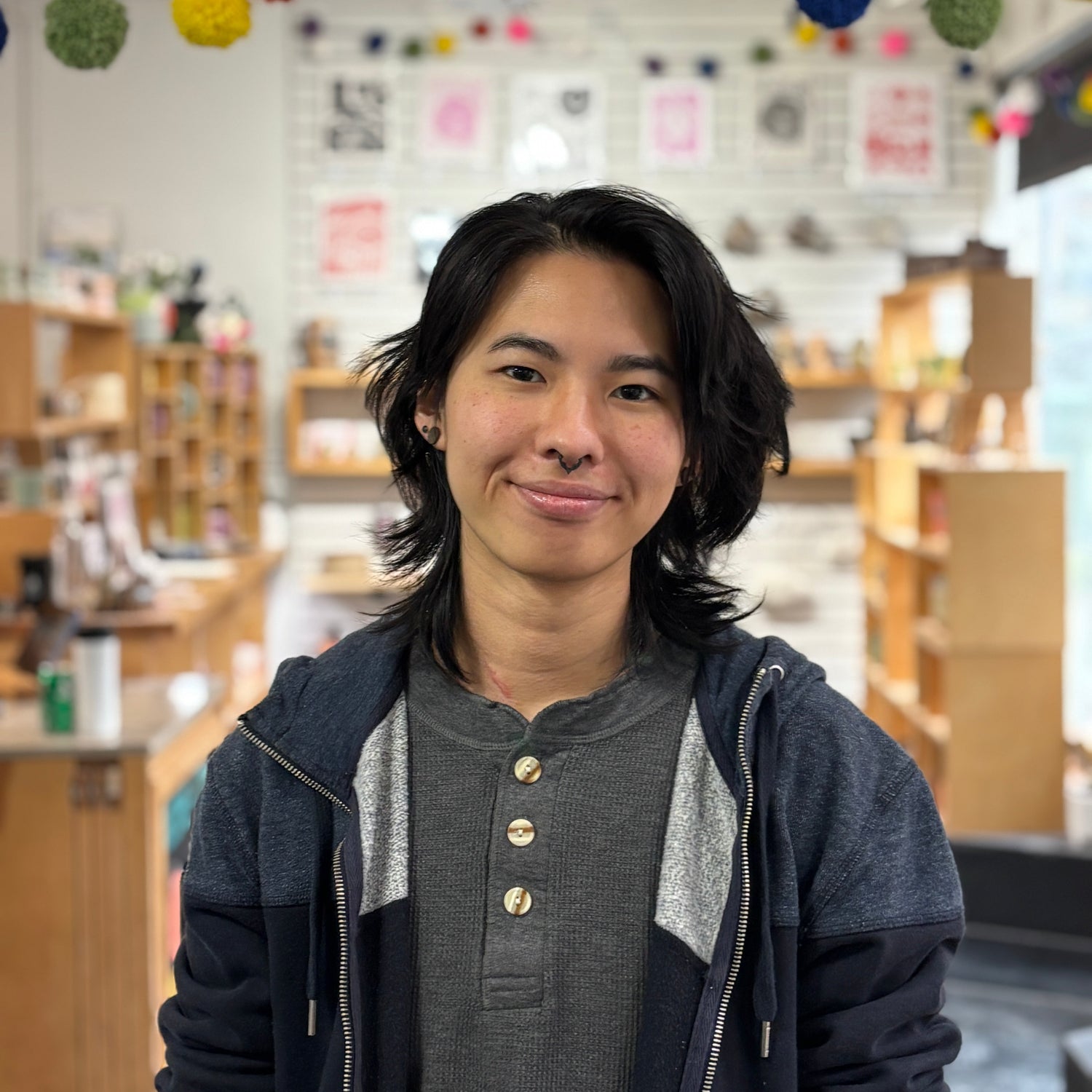 Person standing in a store with colorful decorations in the background